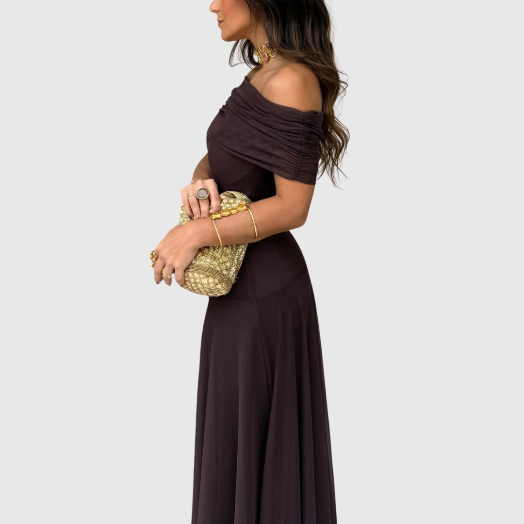 Close side view of woman in brown off-shoulder dress holding a gold woven handbag – Nahansicht der Seite einer Frau im braunen Kleid mit goldener Flechttasche.