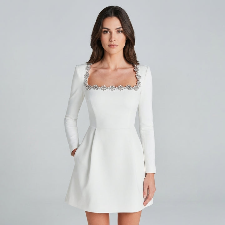 Abito mini bianco con gioielli e maniche lunghe